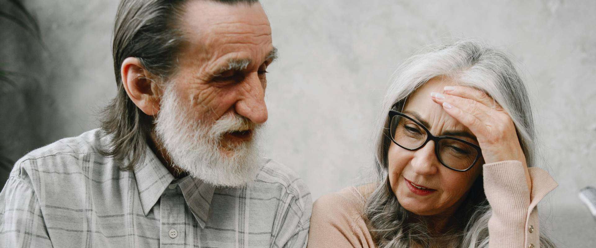 Elderly couple discussing questions to ask about cremation services in Arizona while looking at a laptop.