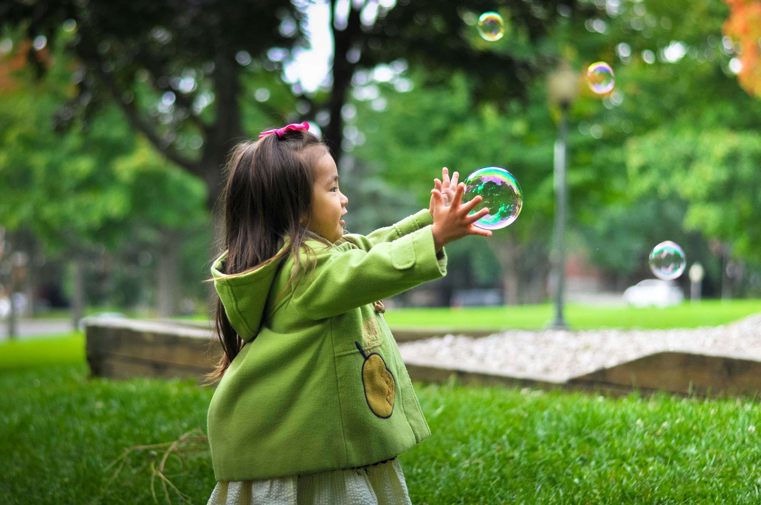 Young child playing with bubbles in a park – symbolizing life’s joy and gentle remembrance, used on Gilbert, Arizona direct cremation page.